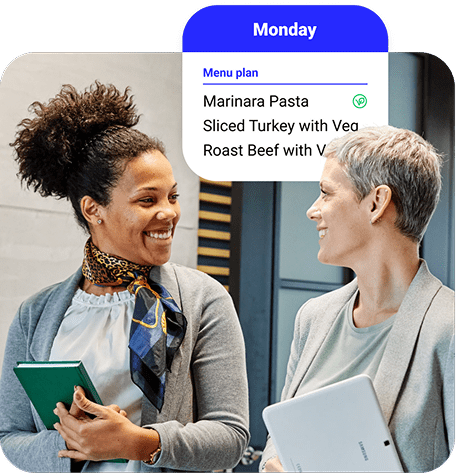 Two co-workers having a conversation about the day’s school meal schedule.