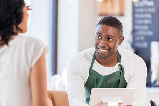 Retail employee smiling while taking order