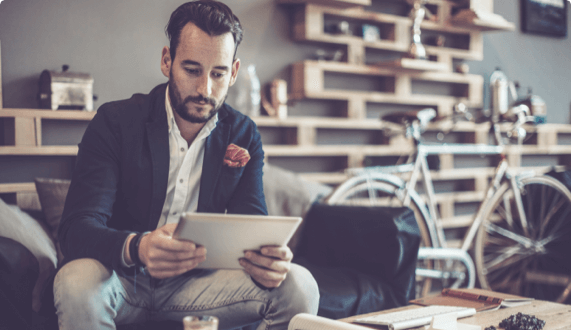 Man sitting in apartment looking at tablet